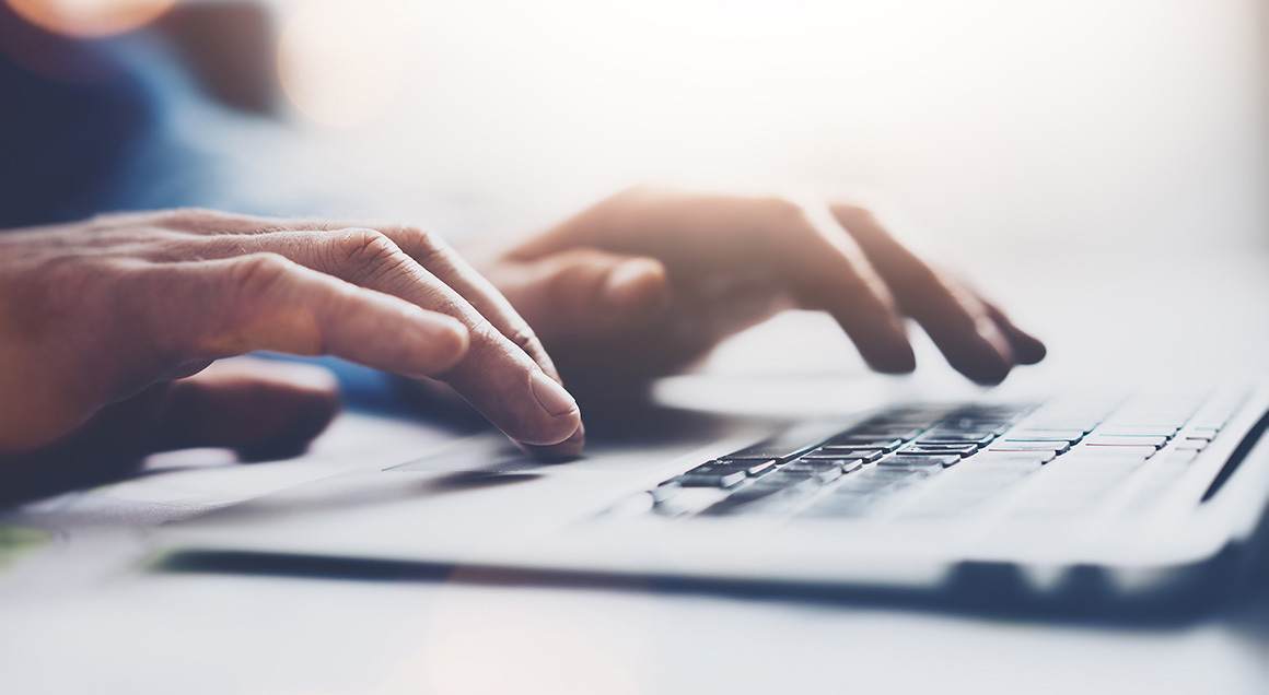 Hands typing on keyboard 1160x636