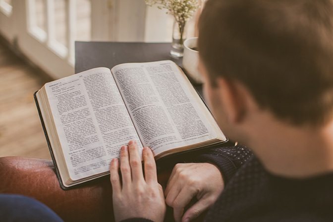 Stock behind the back of man reading bible