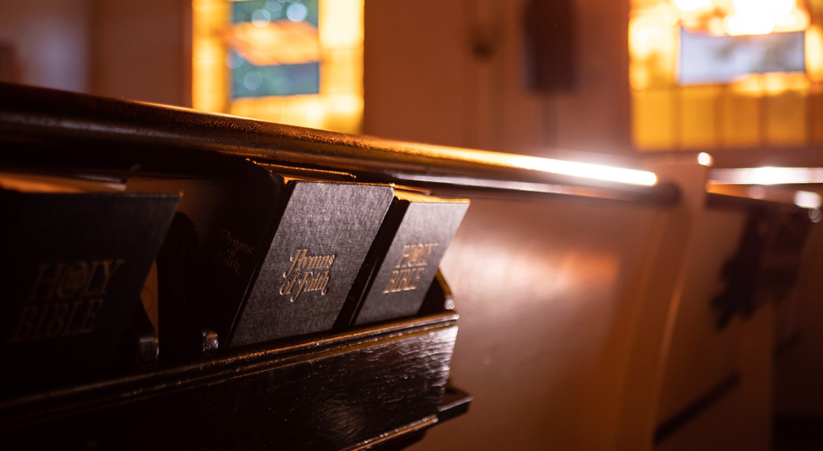Stock hymnal and bible on back of pew