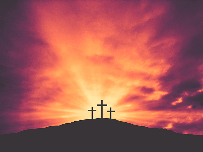Stock three crosses against sunset