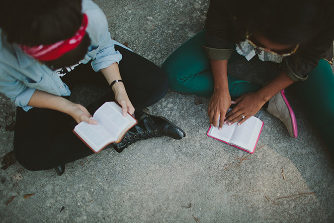 Stock two friends reading bible