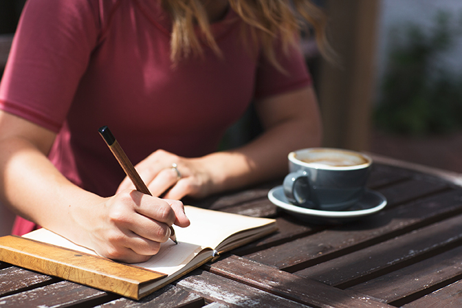 Stock woman writing in notepad