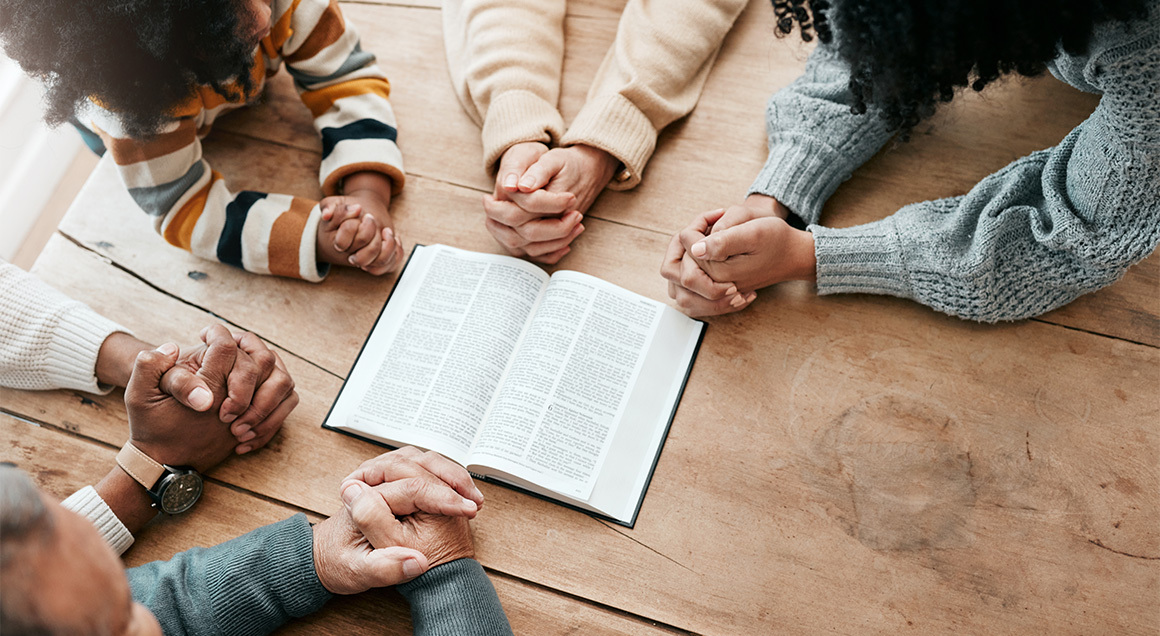 I S Family Praying Around Bible